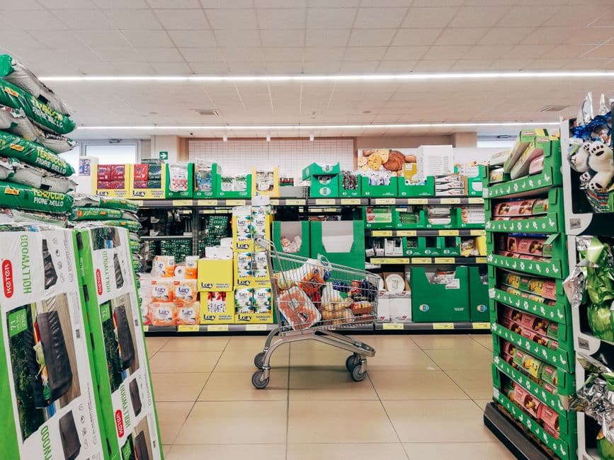 A shopping cart standing in a supermarket aisle