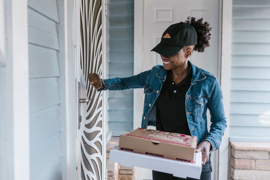 A delivery courier knocking on a front door