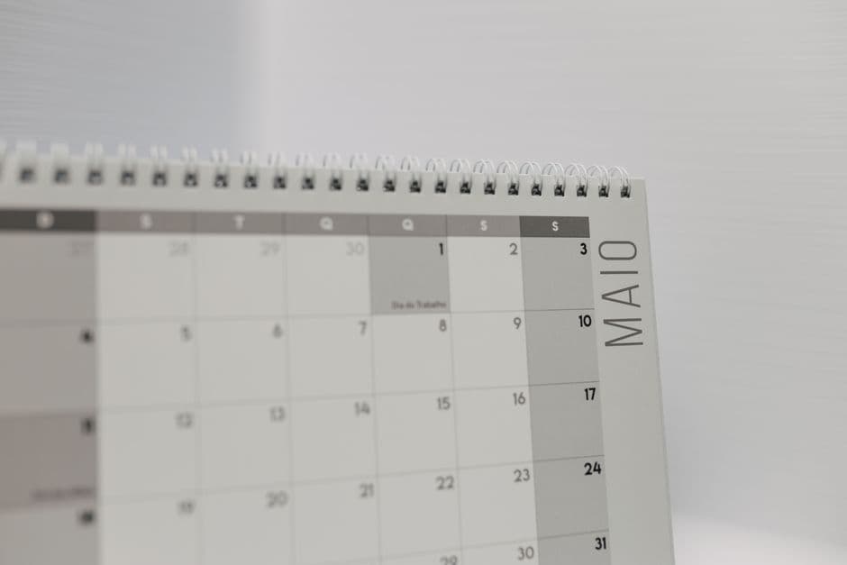 A spiral-bound wall calendar on a desk