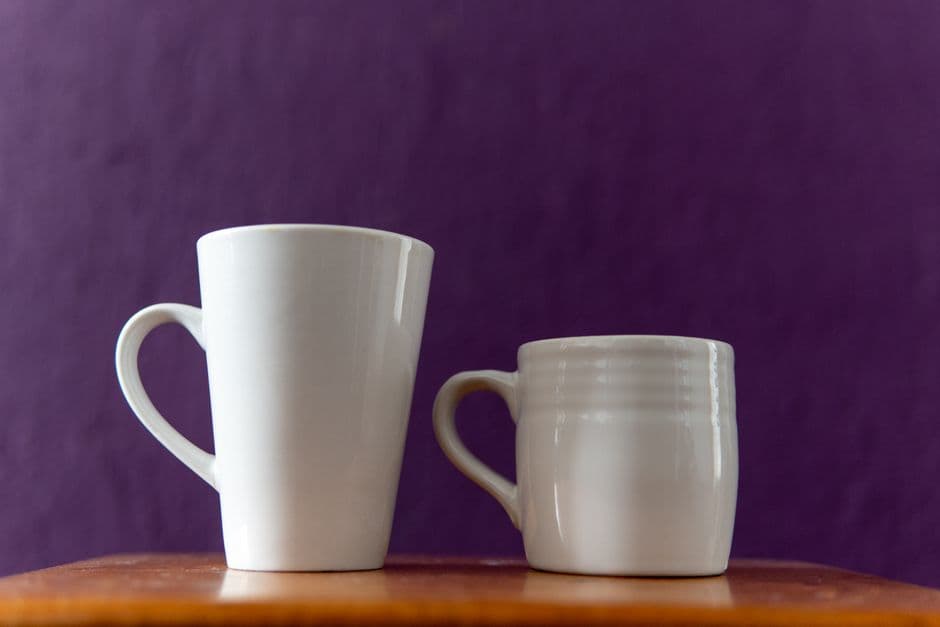 Two near-identical white cups side by side
