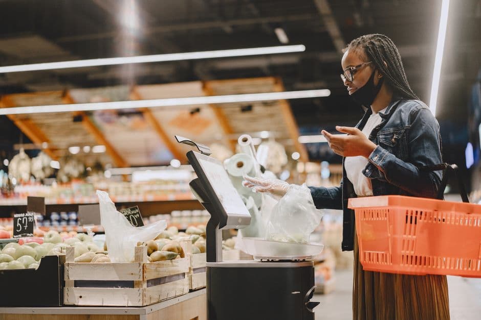 A shopper weighing groceries in a store