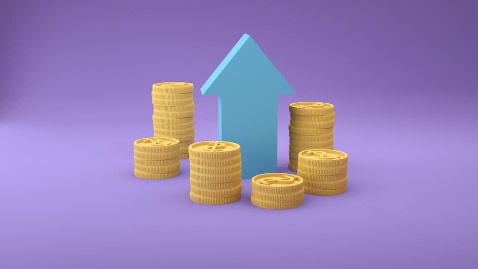 Stacks of coins rising in height beside an upward arrow