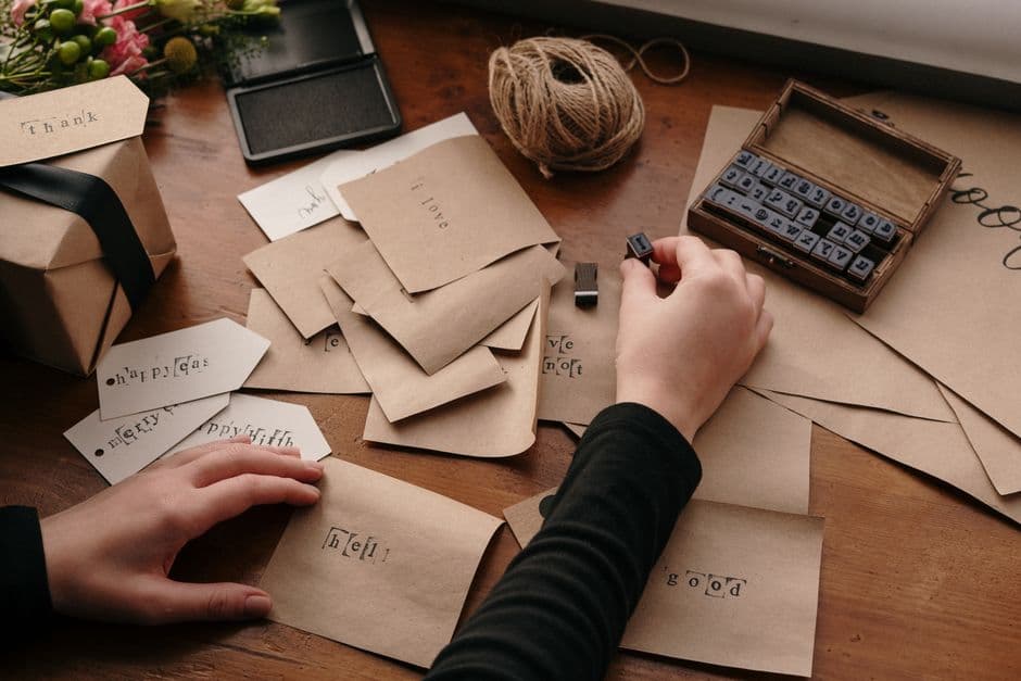 A person stamping envelopes and letters at a desk