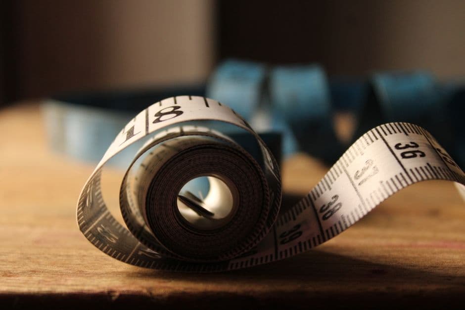 A rolled measuring tape on a wooden surface