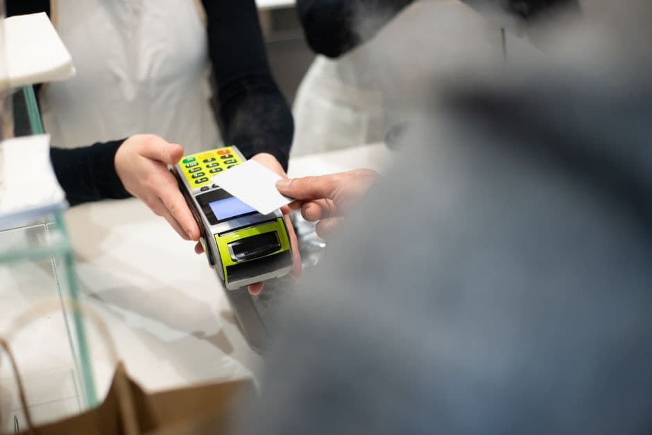A customer paying with a card at a counter