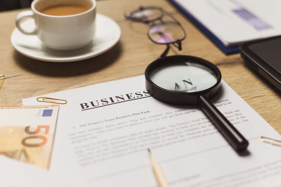 A magnifying glass and a cup of coffee on a desk