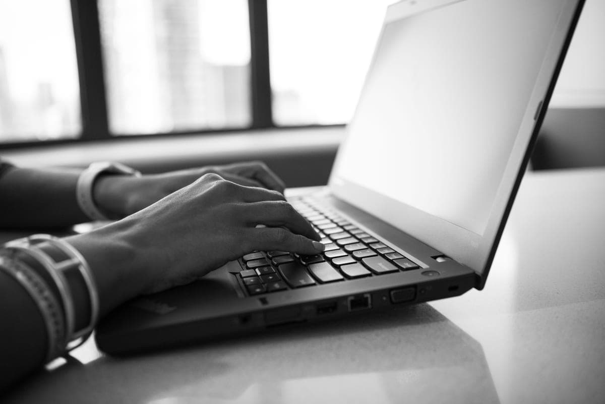Hands typing on a laptop keyboard