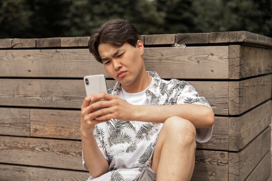 A person frowning at a phone screen