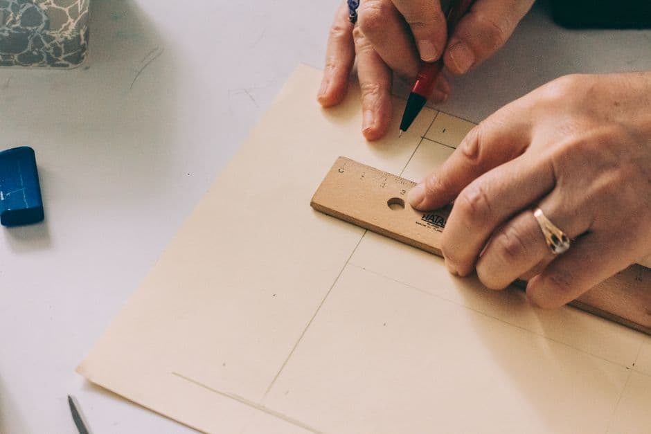 Hands measuring a sheet of paper with a ruler