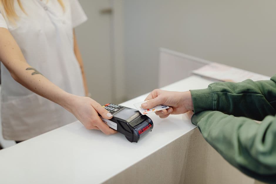 A person holding a bank card at a checkout counter