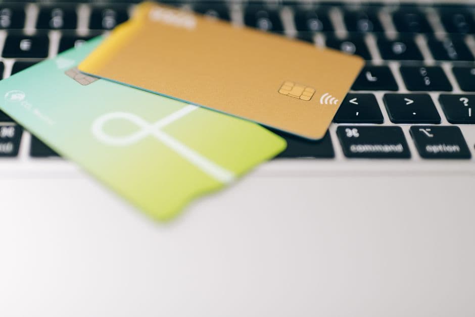 Two credit cards resting on a laptop keyboard