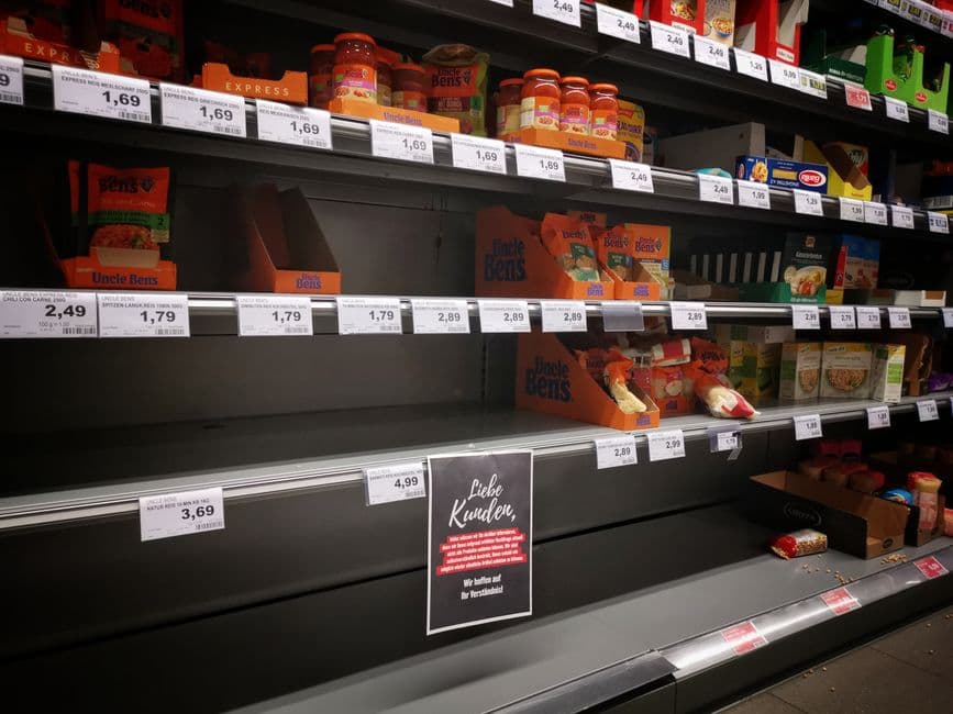 Assorted products on half-empty supermarket shelves