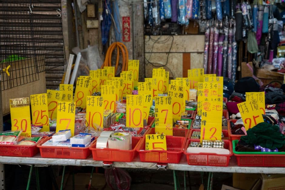 A market stall display with bold sale tags on the goods
